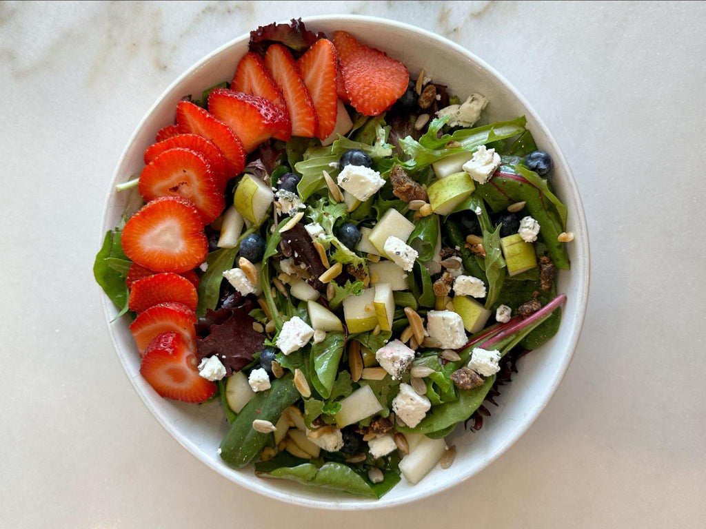 Strawberry Spring Salad topped with fruit, goat cheese, figs & nuts